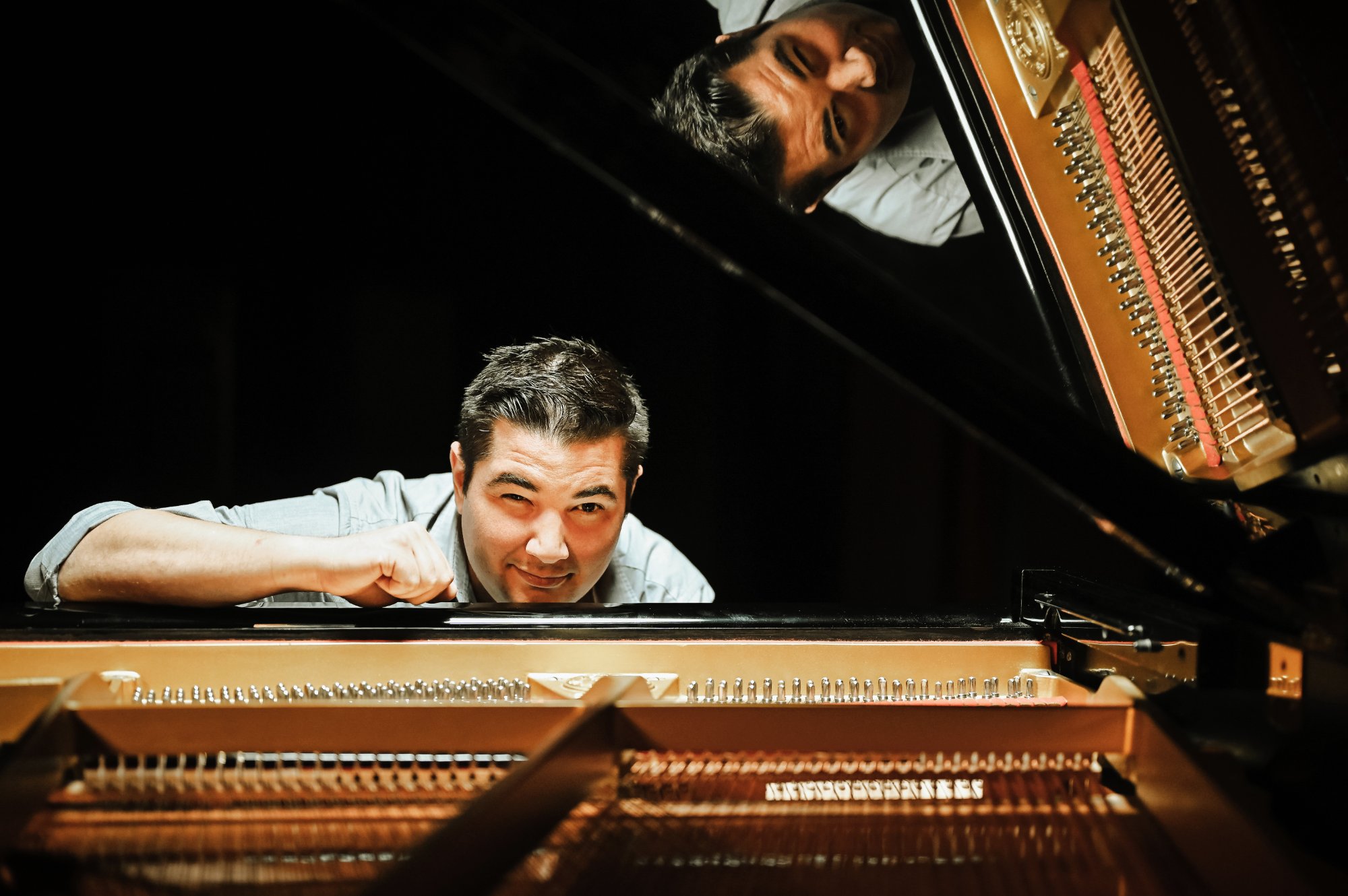 Danny K leaning on piano